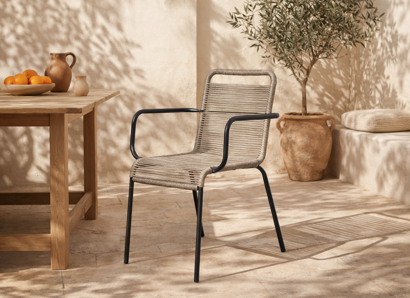 Dumo dining chair in black and natural rope styled in a sunlit mediterranean inspired australian courtyard with warm stone textures