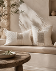Dune rectangle and square cushions styled on a built in bench, showcasing soft woven textures and warm neutral tones in a relaxed Mediterranean inspired setting.