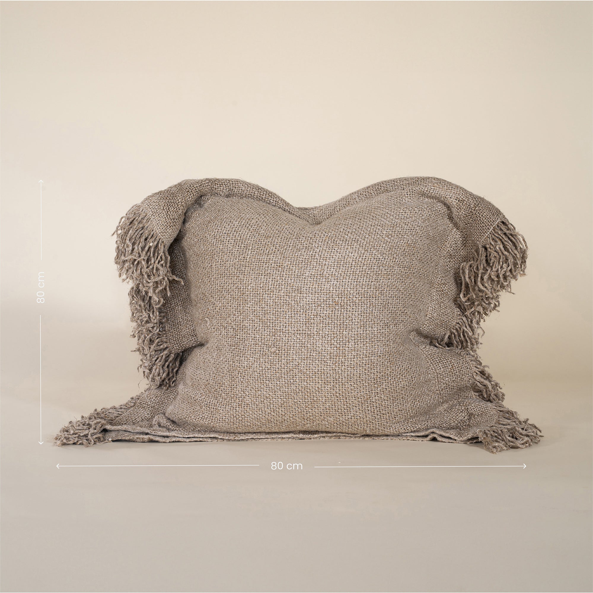 A beautifully textured handwoven linen cushion cover in a soft natural hue, featuring delicate fringe details for a relaxed, organic look. Ideal for layering on sofas or beds