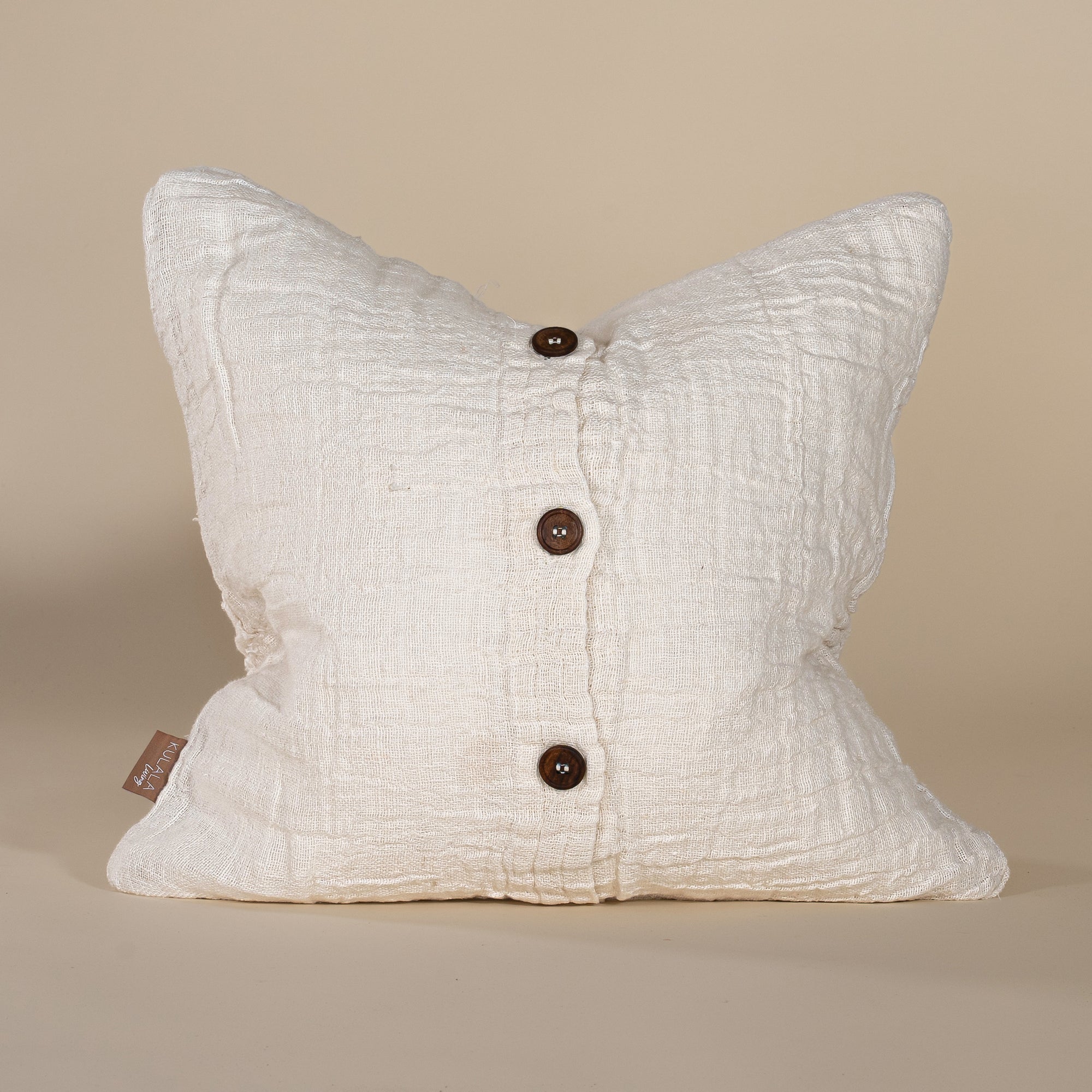 Soft off-white linen cushion with a hand-stitched patchwork design, adding texture and warmth to any living space