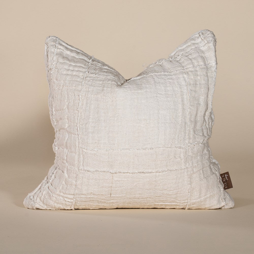 Soft off-white linen cushion with a hand-stitched patchwork design, adding texture and warmth to any living space