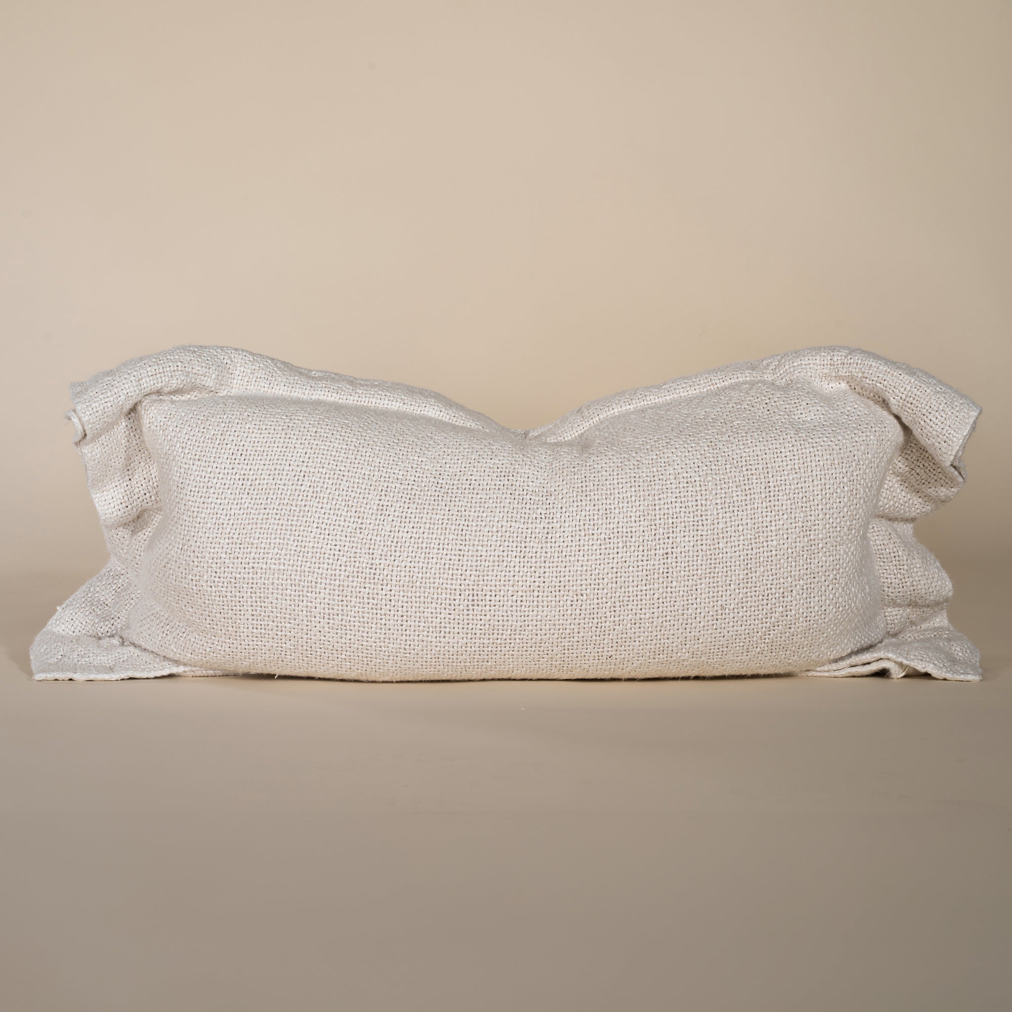 A soft, handwoven linen cushion cover in a natural off-white hue, featuring a relaxed, textured finish. Perfect for adding an organic touch to any living space