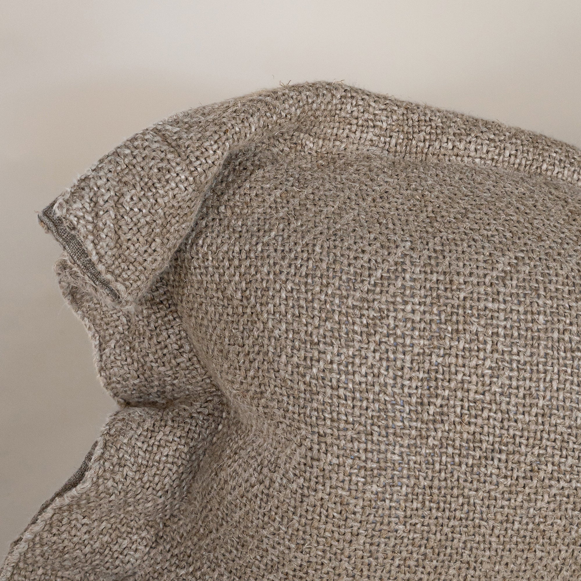 A soft, handwoven linen cushion cover in a natural hue, featuring a relaxed, textured finish. Perfect for adding an organic touch to any living space.
