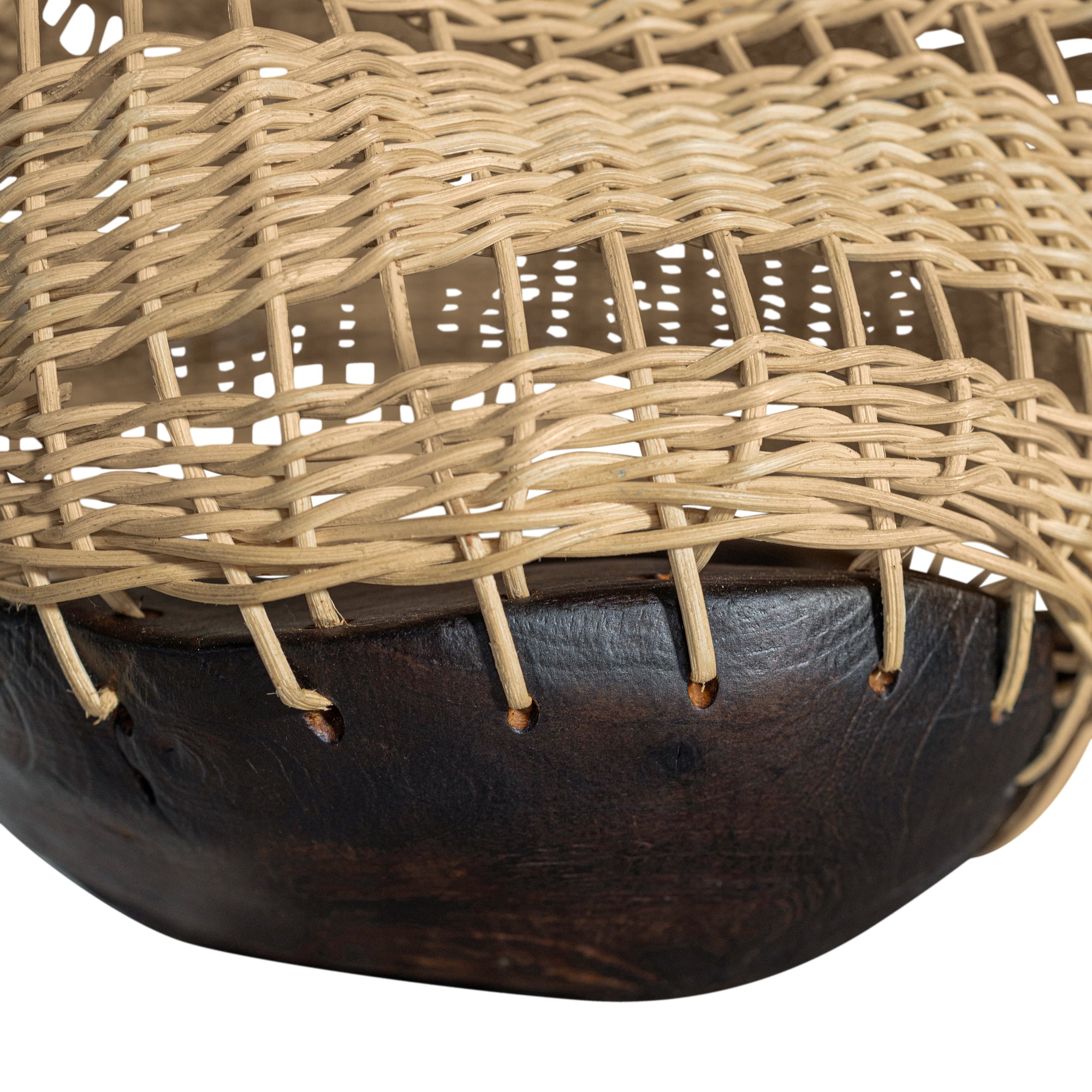 A unique handwoven rattan decorative basket with an open-weave design and a dark wooden base. A statement piece that adds texture and organic warmth to any interior
