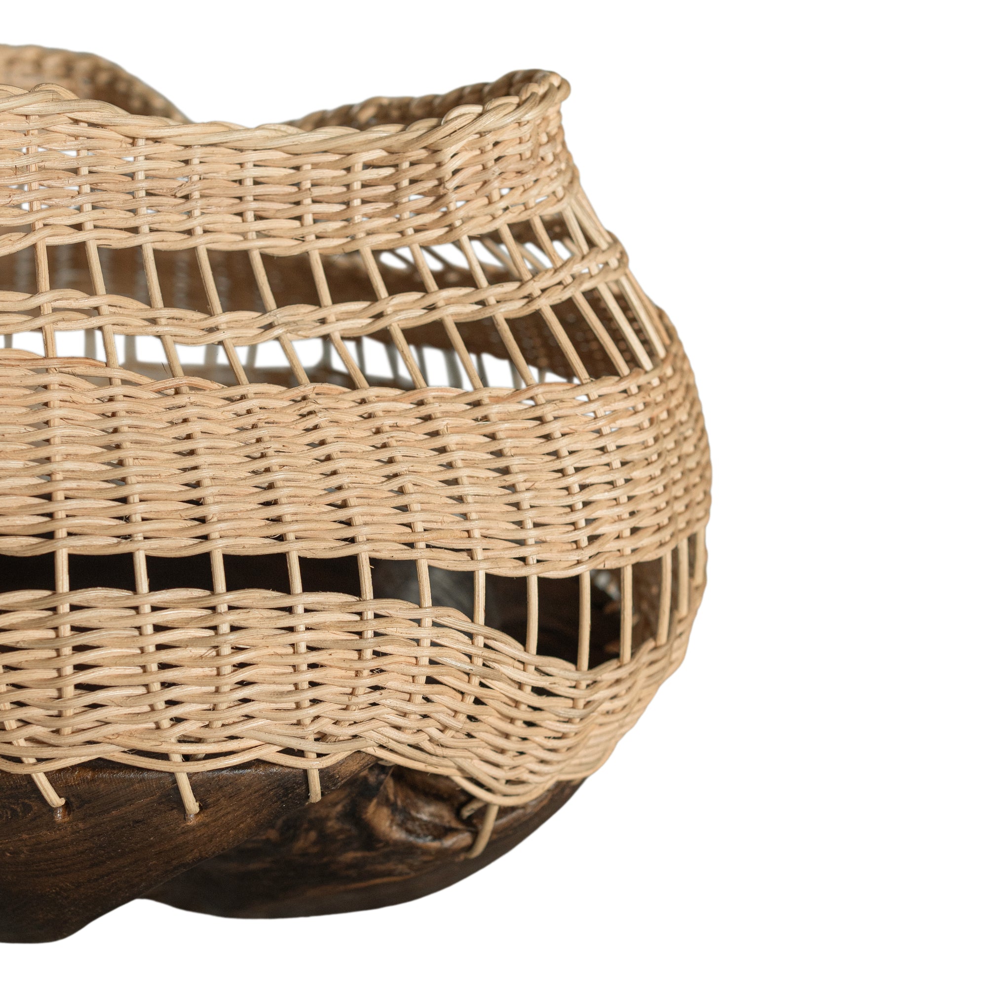A unique handwoven rattan decorative basket with an open-weave design and a dark wooden base. A statement piece that adds texture and organic warmth to any interior