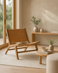 Teak lounge chair with woven herringbone seat and backrest, styled in a minimalist living space with neutral tones, timber furniture, and ceramic vases.