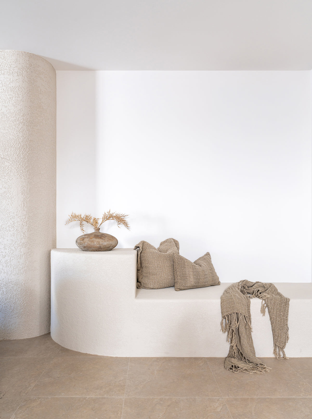 KULALA Living Katanga Vase, Sage Linen Cushion and Gaya Linen Cushion styled on a curved white built in bench in a minimalist neutral interior.
