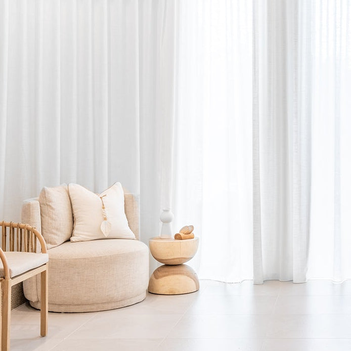 Modern living room with neutral tones and curved armchair furniture
