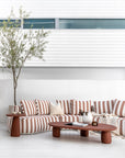 Laguna sofa in cinnabar clay stripe styled with Lantara coffee table and side table creating a warm earthy outdoor living setting.