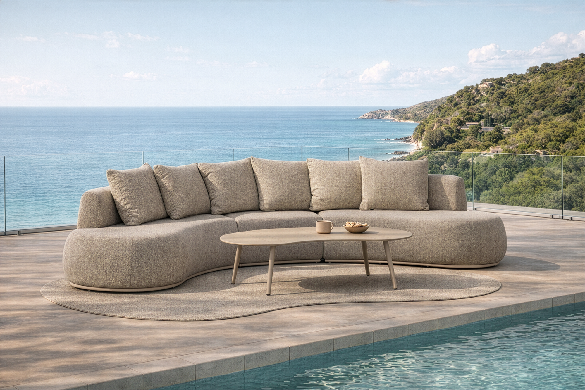 Laguna modular sofa in oat drift fabric paired with Solara coffee table styled beside a pool overlooking a coastal landscape.