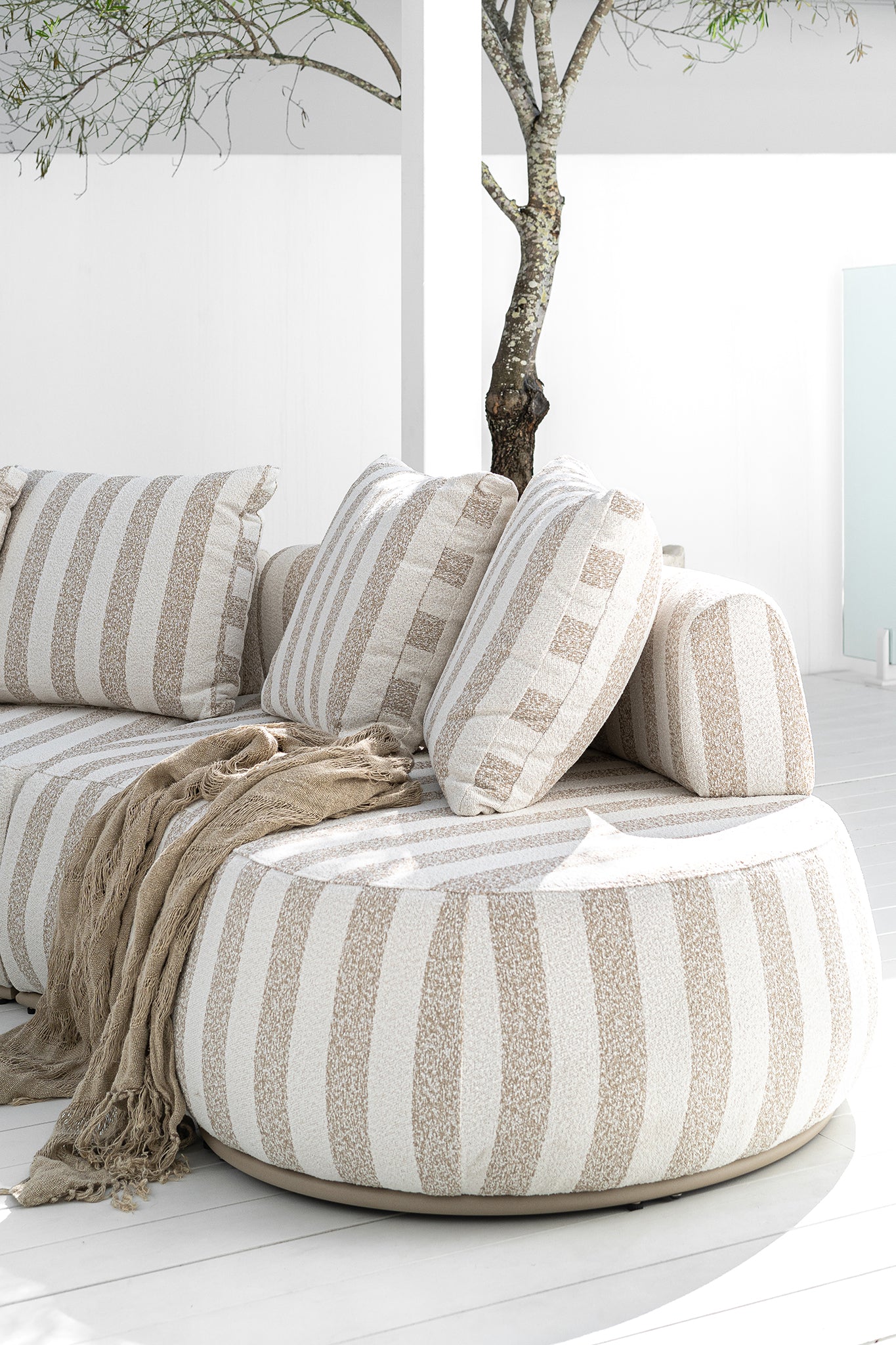 Laguna sofa in sand stripe fabric creating a relaxed coastal outdoor setting.