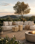 Laguna Sofa in Sand Stripe styled on a sunset garden terrace with warm natural textures and relaxed outdoor living.