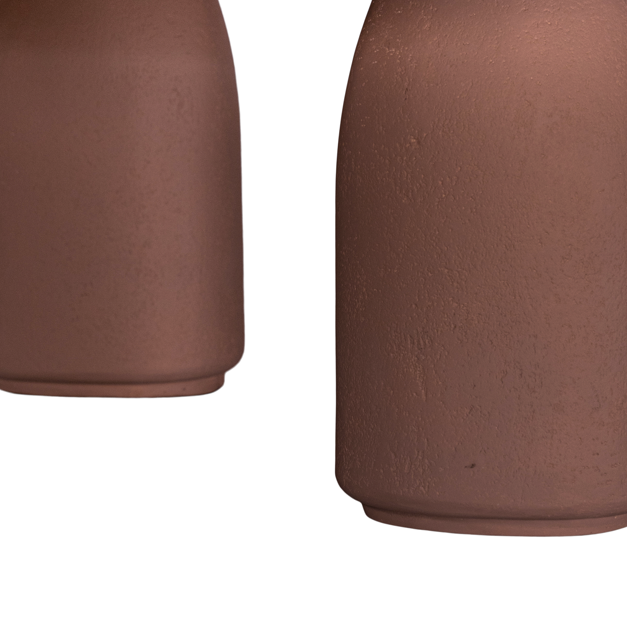 Lantara coffee table in cinnabar clay finish with elongated oval top and three rounded sculptural legs.
