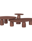 Lantara coffee table in cinnabar clay finish with elongated oval top and three rounded sculptural legs.