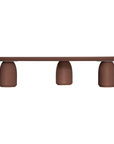 Lantara coffee table in cinnabar clay finish with elongated oval top and three rounded sculptural legs.