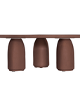Lantara coffee table in cinnabar clay finish with rounded top and three rounded sculptural legs.