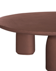 Lantara coffee table in cinnabar clay finish with rounded top and three rounded sculptural legs.