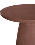 Lantara side table in a cinnabar clay finish with round top and elongated sculptural leg.