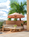 Lantara side table and large coffee table at Ruma rooftop bar styled with curved seating and umbrella creating a relaxed sunlit setting with natural textures.