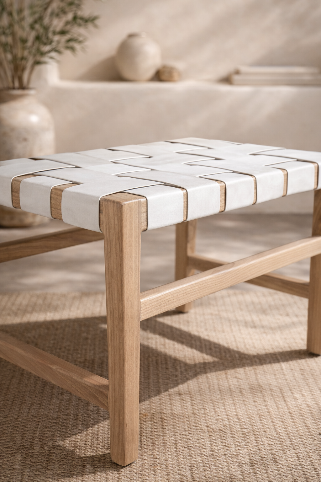 Lazzy low stool with natural timber frame and white woven seat, styled in a soft neutral interior with textured rug and warm organic decor.