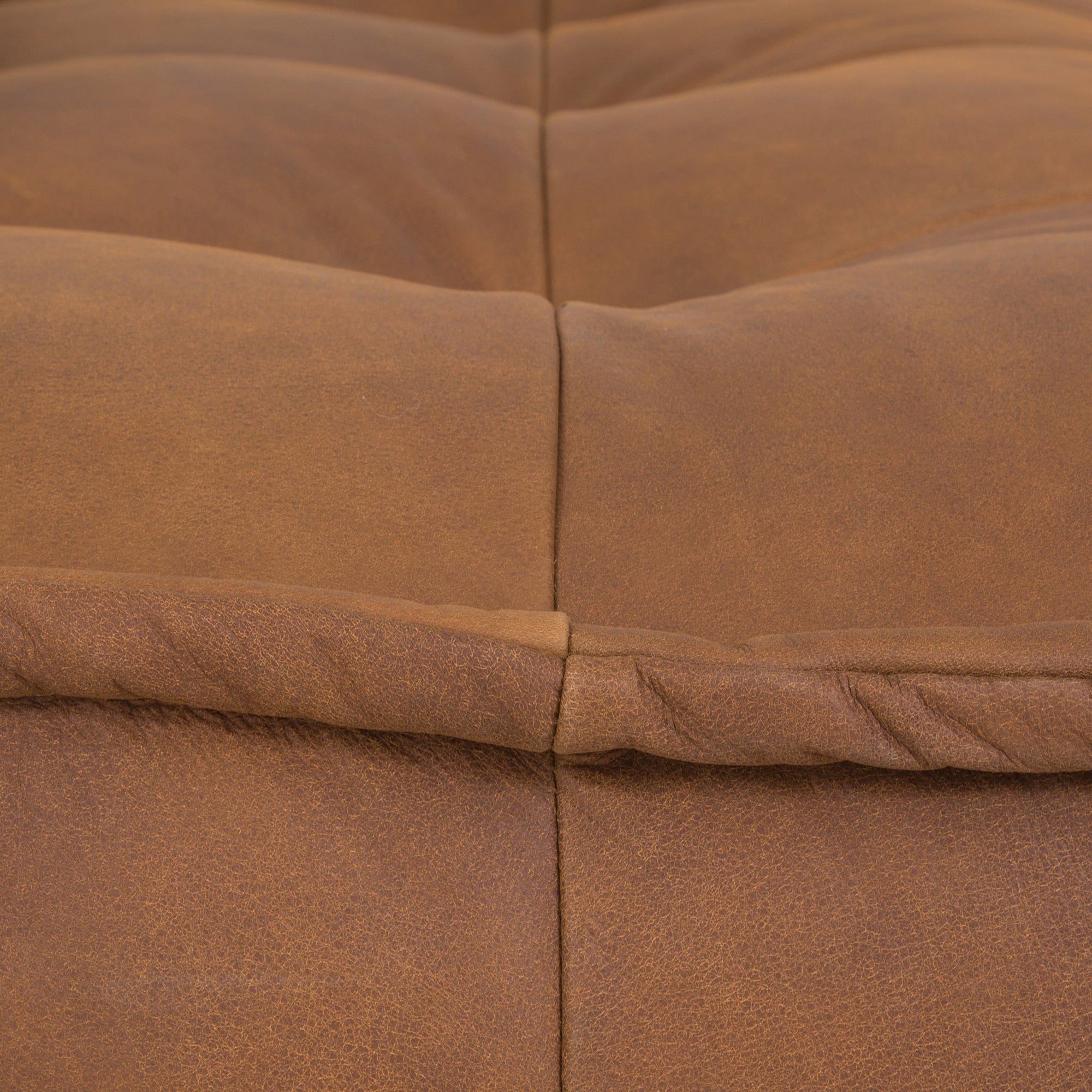 A stylish leather modular sofa with a low-profile design and plush cushioning, offering a relaxed and contemporary seating option for modern interiors