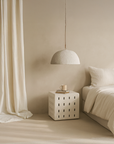 KULALA Living Lindiwhe Pendant light and Niche Side Table styled in a soft neutral bedroom with minimal furnishings and layered natural textures