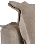 A plush linen slipcover ottoman in a warm taupe tone, featuring a relaxed silhouette with a soft cushion top. Perfect for versatile seating, a footrest, or as a stylish accent in contemporary and coastal-inspired interiors