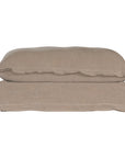 A plush linen slipcover ottoman in a warm taupe tone, featuring a relaxed silhouette with a soft cushion top. Perfect for versatile seating, a footrest, or as a stylish accent in contemporary and coastal-inspired interiors