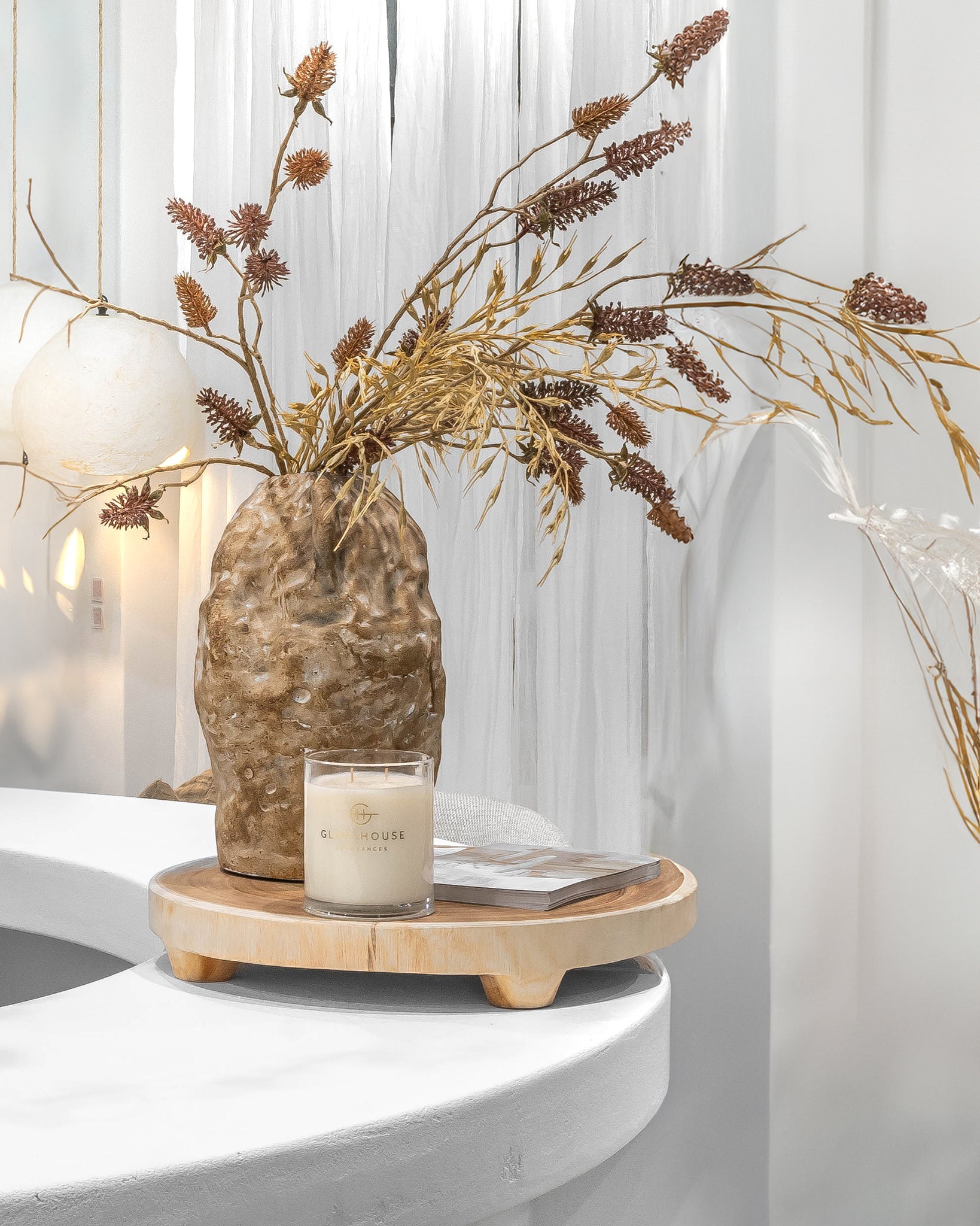 Lumara cheese plate in solid natural wood with round profile, visible timber grain and low pedestal feet.