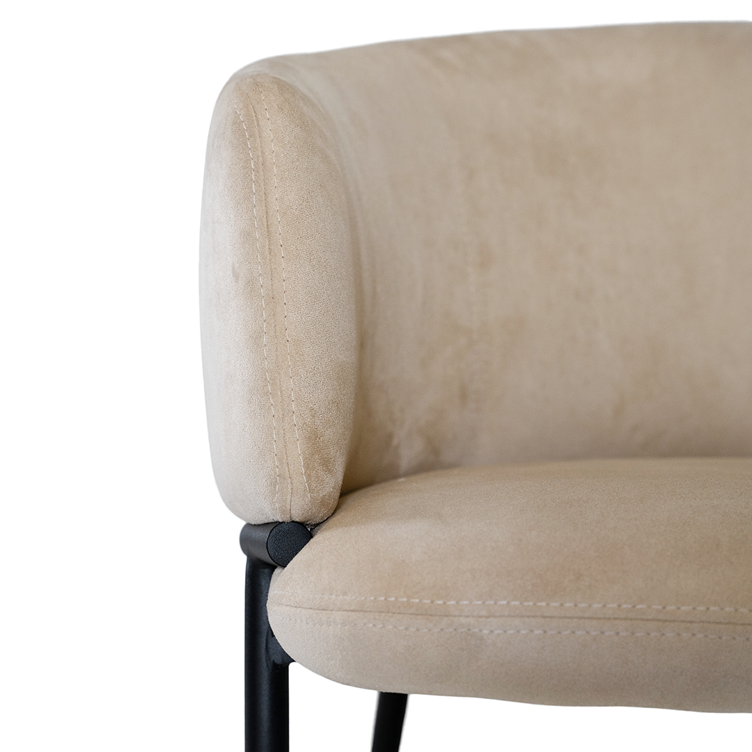 Lumo dining chair in bone with soft upholstered seat and curved backrest on slim black legs shown in a clean minimal setting.