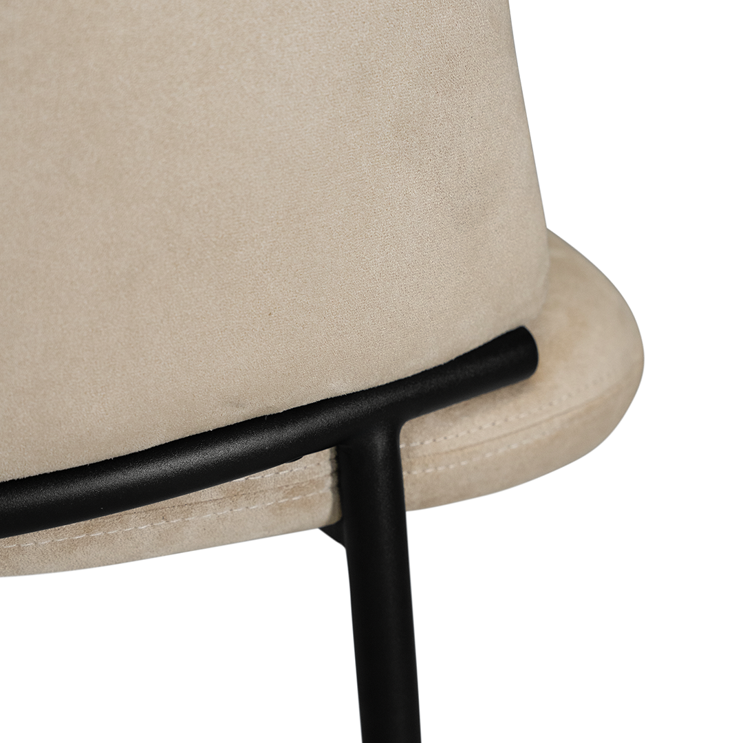 Lumo dining chair in bone with soft upholstered seat and curved backrest on slim black legs shown in a clean minimal setting.