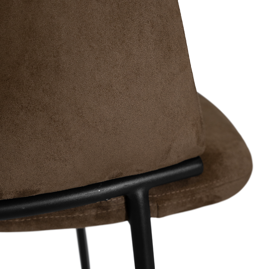 Lumo dining chair in cocoa with soft upholstered seat and curved backrest on slim black legs shown in a clean minimal setting.
