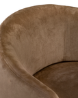 Lumo dining chair in hazelnut with soft upholstered seat and curved backrest on slim black legs shown in a clean minimal setting.