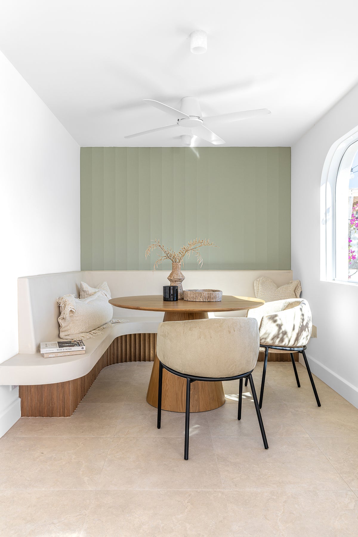 KULALA Living Lumo Dining Chairs and Kuba Oak Dining Table styled with Gaya and Harvest Cushions, Mayi Bowl and Kivu Vase in a bright coastal dining nook with curved built in seating and sage green walls.