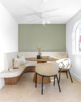 KULALA Living Lumo Dining Chairs and Kuba Oak Dining Table styled with Gaya and Harvest Cushions, Mayi Bowl and Kivu Vase in a bright coastal dining nook with curved built in seating and sage green walls.