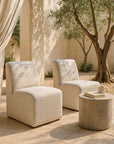 Pair of Martinique Low Chairs styled outdoors with a round concrete side table, neutral palette and Mediterranean-inspired garden setting