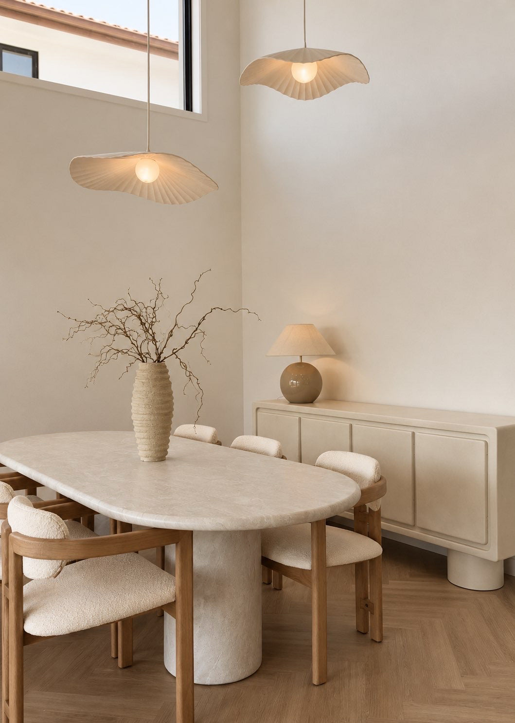 KULALA Living Matisse Arm Chairs featuring natural timber frames, curved armrests and textured cream upholstery, styled around a stone dining table in a neutral dining room.