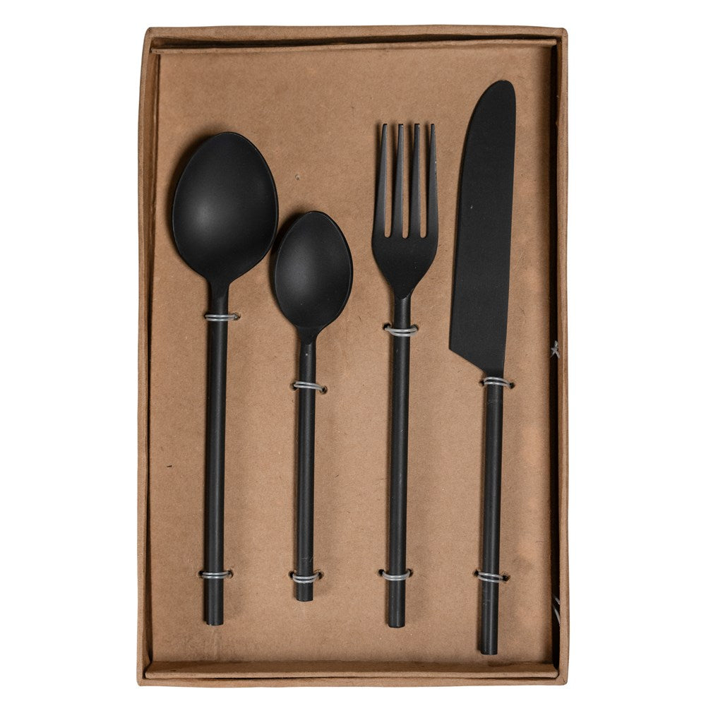 A sophisticated matte black cutlery set presented in a minimalist kraft box, featuring a modern fork, knife, tablespoon, and teaspoon with sleek, contemporary handles
