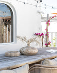 Mayi handcrafted terracotta bowl and Katanga Vase styled on a rustic timber outdoor dining table in a relaxed coastal setting.