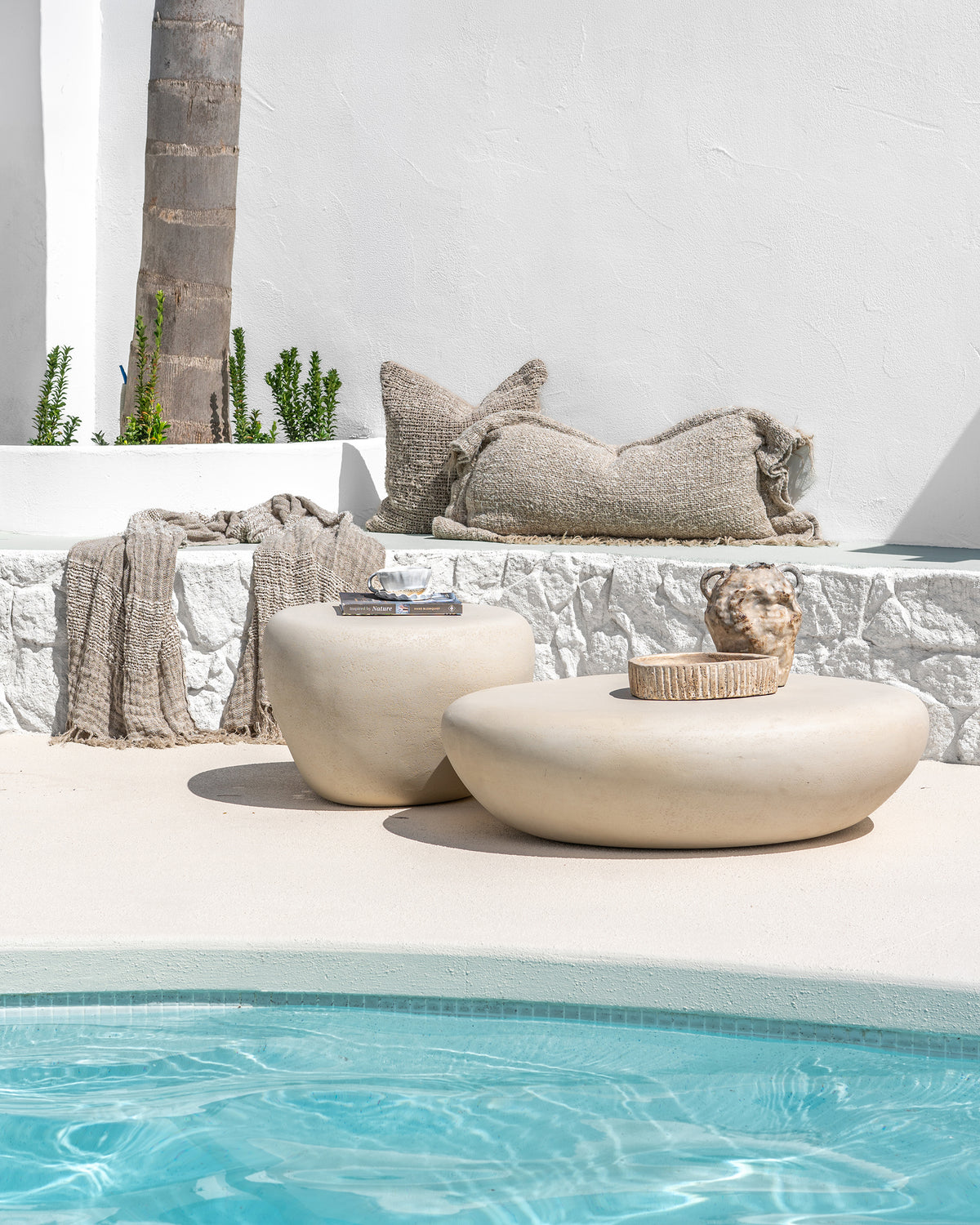 Mayi Pot, Ukoko Pot, Freya Cushion, Cairo Cushion and Cairo Linen Throw styled in a relaxed neutral poolside setting.