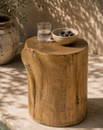 Natural Meera stool crafted from magnesium oxide styled beside a poolside daybed creating a warm organic retreat with rustic character and natural textures.