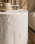 White magnesium oxide Meera stool styled beside an outdoor lounge creating a light and tranquil setting with soft textures and natural Mediterranean inspired warmth.