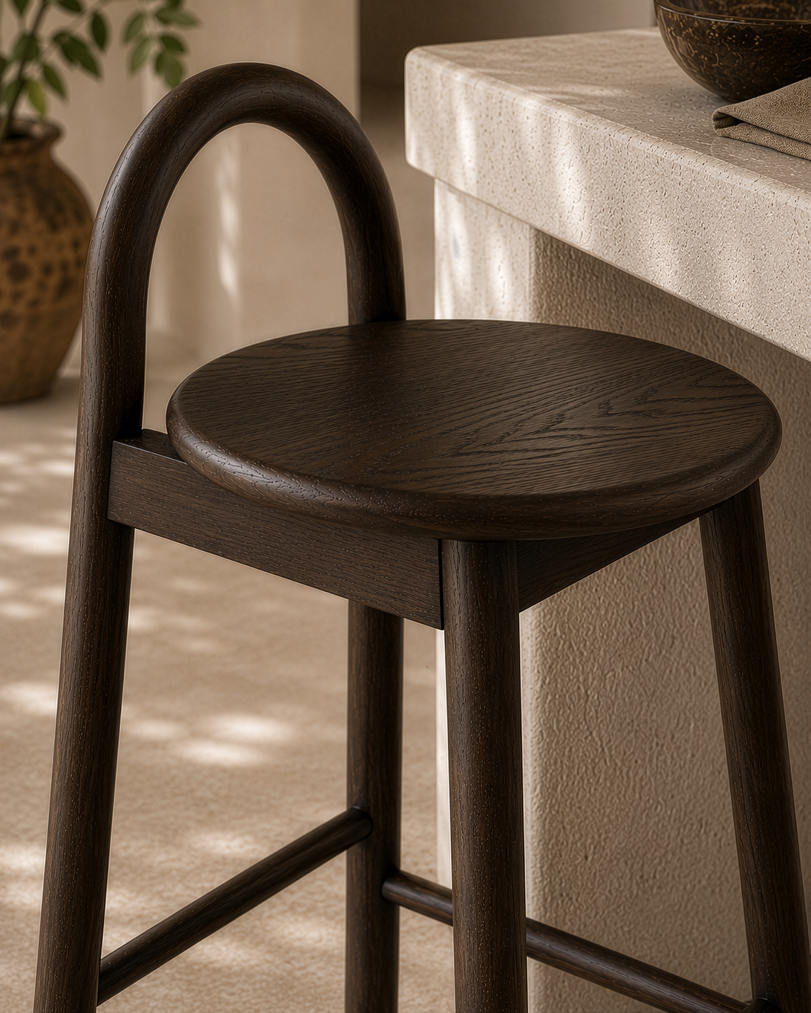 Milo barchair in espresso finish styled beside a textured stone island creating a warm refined kitchen setting with natural earthy tones.
