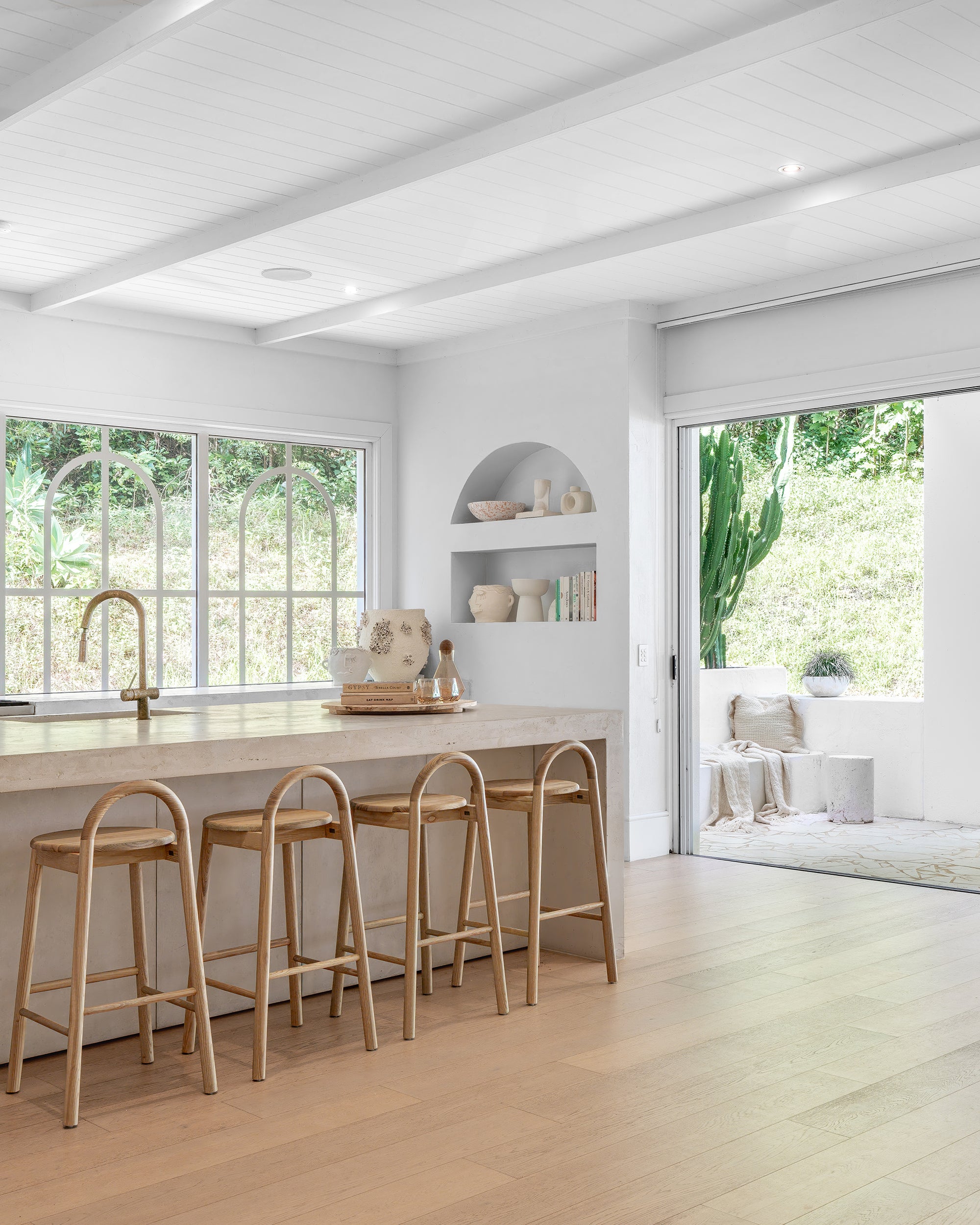 Milo Timber Bar Chair  Barstool in a modern Mediterranean kitchen, featuring natural timber with a sleek and contemporary curved arch design.