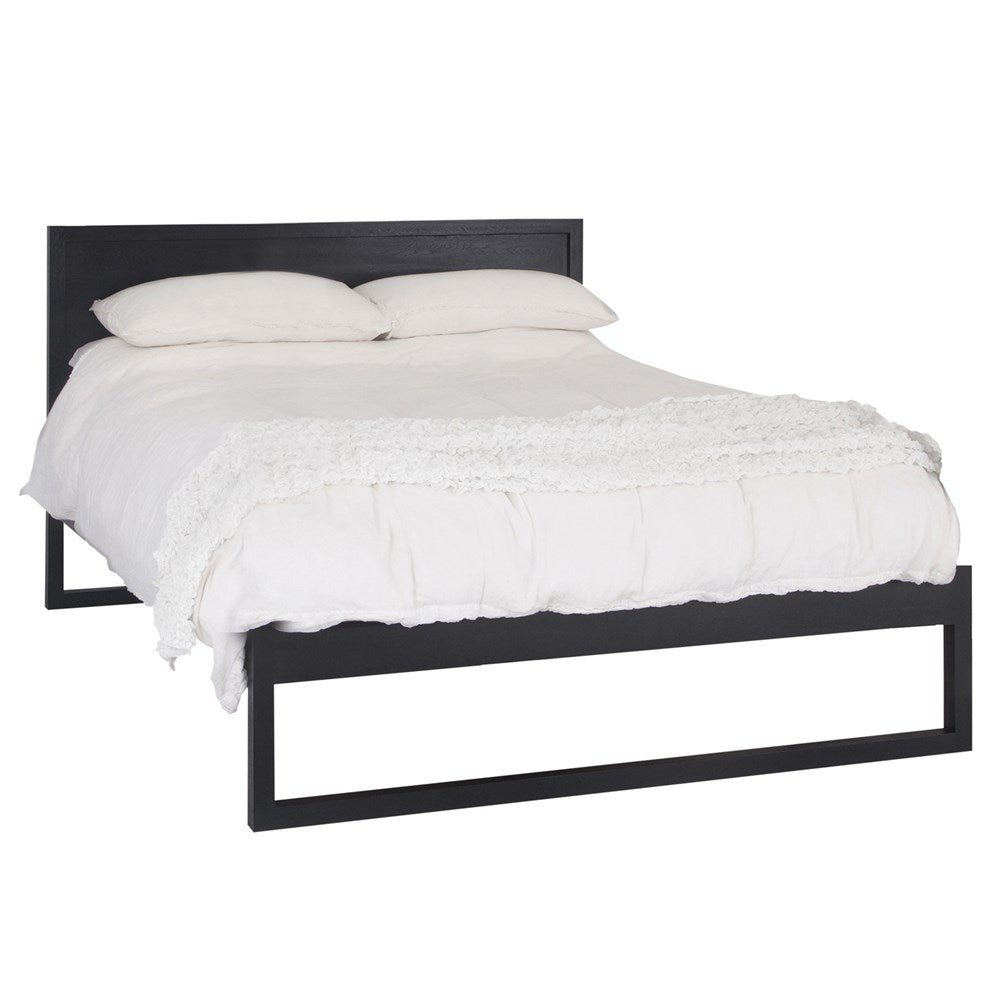 A sleek modern bed frame crafted from dark oak, featuring a minimalist open-base design. The bed is styled with crisp white linen and plush pillows, offering a refined and contemporary bedroom aesthetic