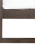 A sleek modern bed frame crafted from dark oak, featuring a minimalist open-base design. The bed is styled with crisp white linen and plush pillows, offering a refined and contemporary bedroom aesthetic