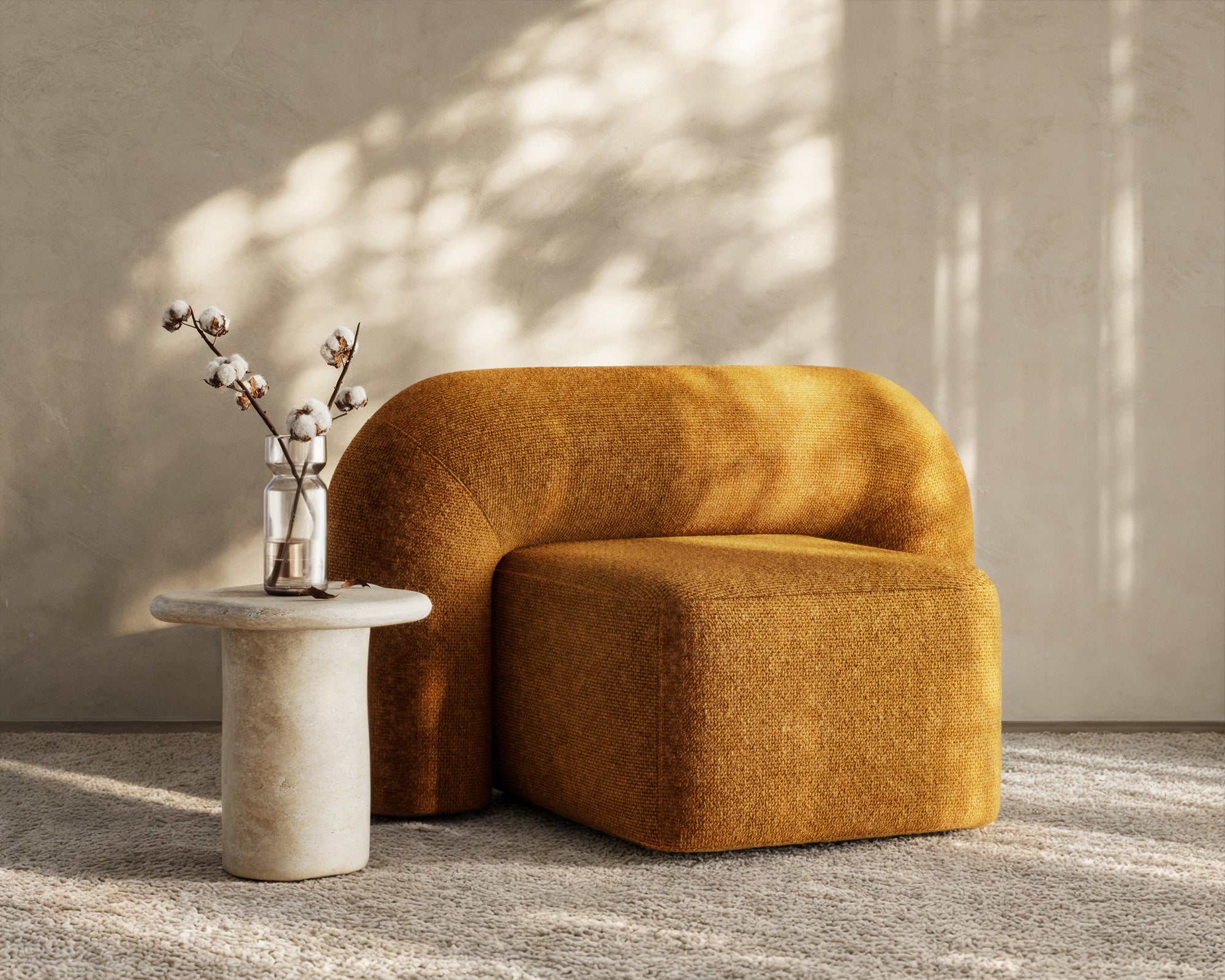 A luxurious mustard velvet lounge chair with a sculptural, curved backrest and a matching ottoman, offering a bold yet elegant statement piece for contemporary interiors
