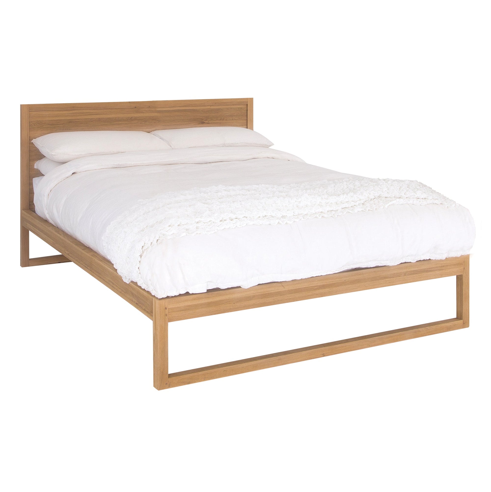 A minimalist oak bed frame with a natural wood finish, styled with crisp white bedding and a textured throw. The sleek and contemporary design complements a serene and stylish bedroom aesthetic