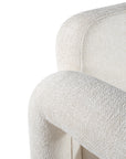 A modern sculptural armchair with rounded, chunky arms and backrest, upholstered in soft white boucle fabric, perfect for contemporary living spaces