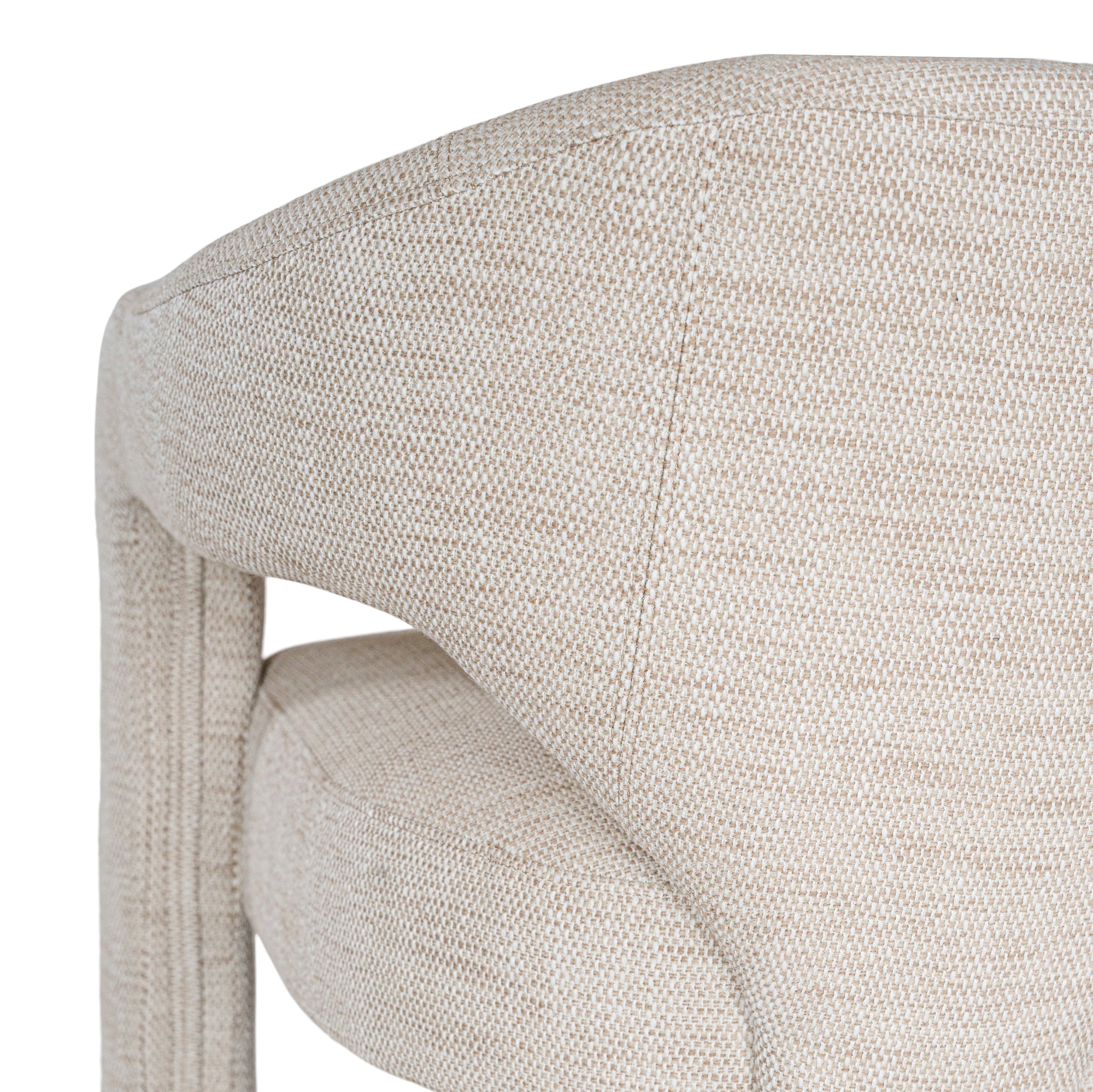 Contemporary upholstered armchair in a soft beige fabric, featuring a sculptural curved frame and plush seating for a modern, sophisticated look.